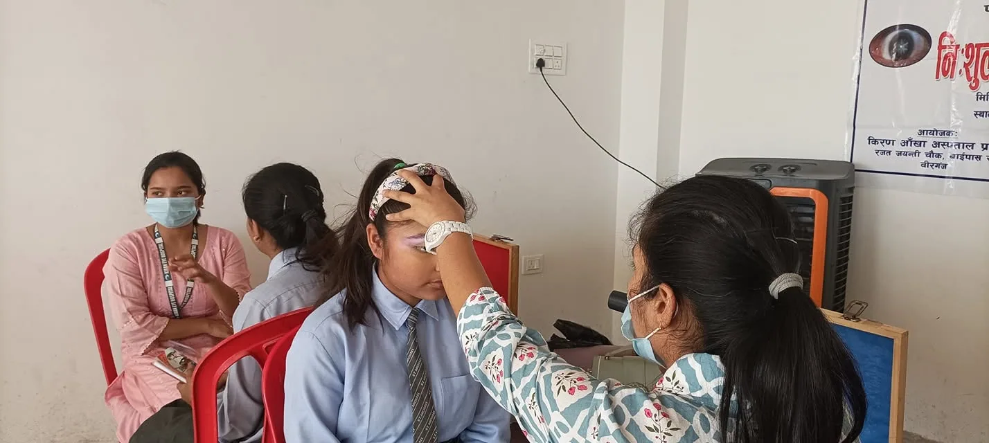 A student having an eye examination at a free health check-up camp held at the school